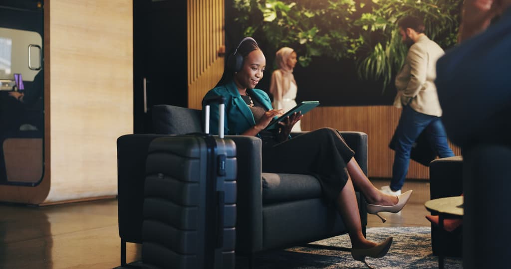 A business woman takes a phone call in a busy hotel lobby