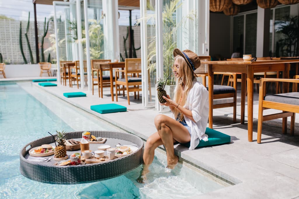 A woman having lunch and a drink by the hotel pool