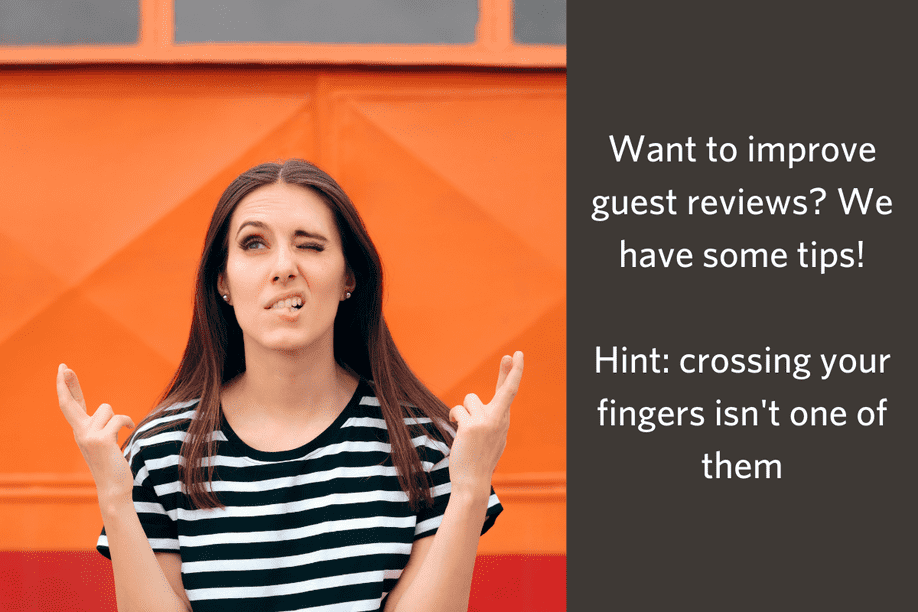 woman sitting at a table with her eyes closed and fingers crossed with text - Want to improve guest reviews? We have some tips! Hint: crossing your fingers isn't one of them